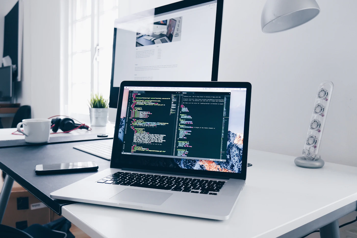 Ordinateur portable affichant du code de site web sur un bureau
